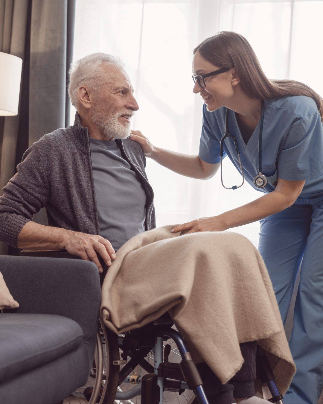 A hospice nurse with a stethoscope attending a patient at home