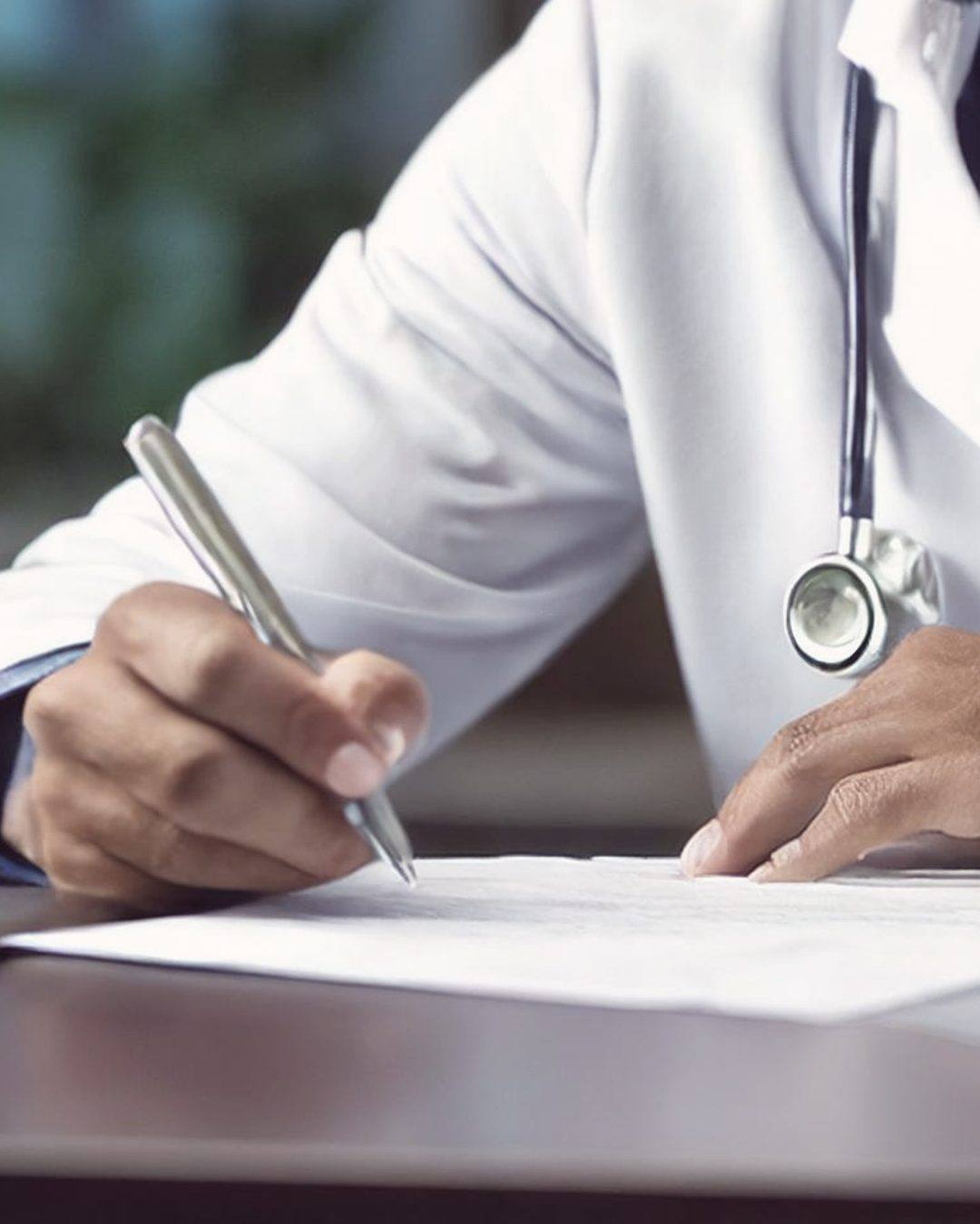 A clinician signing a plan-of-care document at a desk