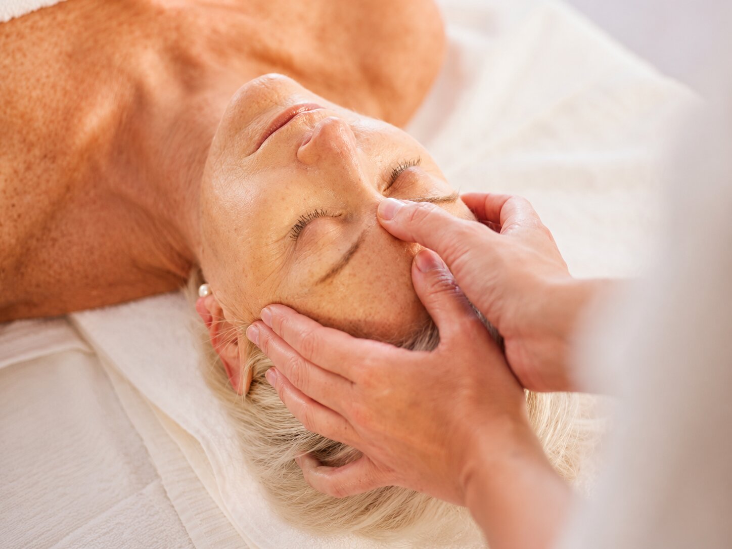 A massage therapist easing tension for an older adult during a calm session